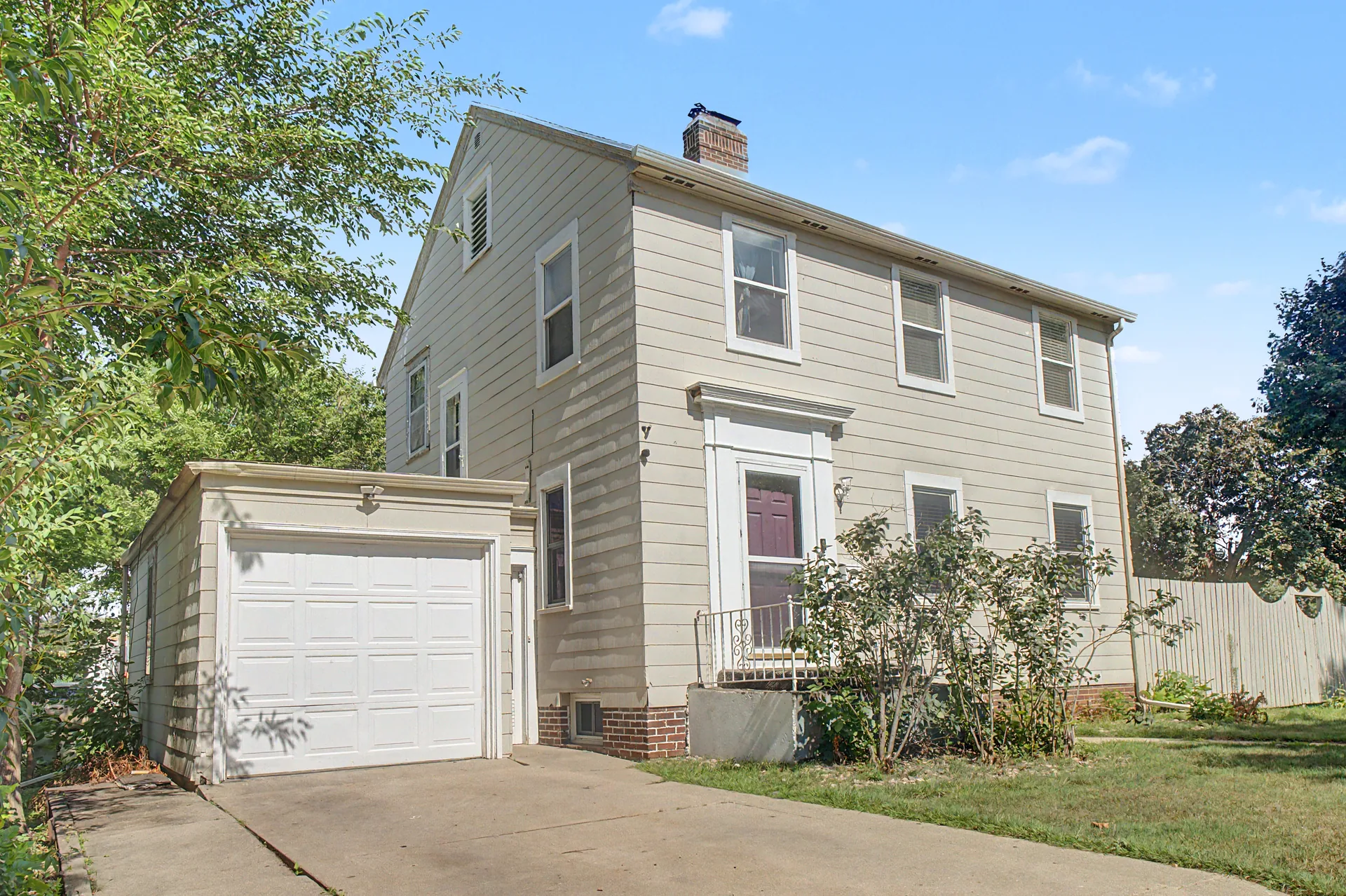 Entry and garage corner of 608 9th Street, Worthington in daylight, before virtual twilight editing